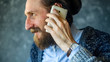 © v_sot - Happy Bearded Man Talk at Phone. Open and Friendly Communication with a Pleasant Interlocutor. Good News Concept