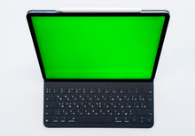 New Tablet On A White Background With A Keyboard And Pen, And Green Screen