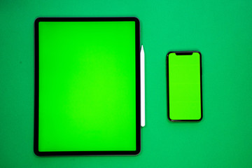 Wall Mural - new tablet on a Green background with a keyboard and pen, and green screen top view