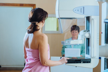 Wall Mural - Female patient under going mammography test in hospital. Back view, selective focus