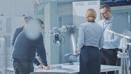 Aufkleber - Diverse Team of Industrial Robotics Engineers Gathered Around Table With Robot Arm, They Use Tablet Computer to Manipulate and Program it to Pick Up and Move Metal Component. Bright Facility
