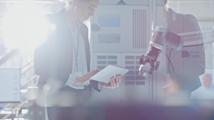 Poster - Stylish Female Industrial Robotics Engineer Uses Tablet Computer to Program and Manipulate Robot Arm for Lifting, Moving Objects. Technology Research Facility for Machine Learning and Cloud Computing