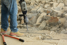 The  Worker Using Dismantling Machine Hitting Into The Concrete  Ground