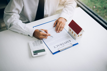 Wall Mural - New home buyers are signing a home purchase contract at the agent's desk.