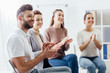 © LIGHTFIELD STUDIOS - smiling group of people sitting and applauding during support group session