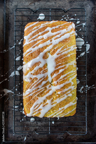 Photographie baked lemon poppy seed cake loaf with white icing drizzle flat lay