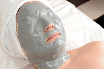 Wall Mural - The girl in the alginate anti-wrinkle mask. Close-up of a woman lying relaxing in a beauty salon. Spa treatments at home or cosmetology center.