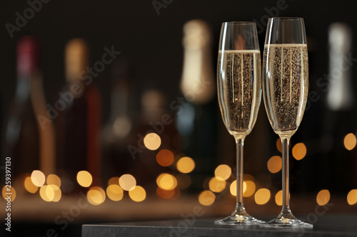 Fotografía Glasses of champagne on table against blurred background