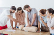 © LIGHTFIELD STUDIOS - group of people with instructor performing cpr on dummy during first aid training