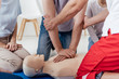© LIGHTFIELD STUDIOS - cropped view of group of people during first aid training with dummy