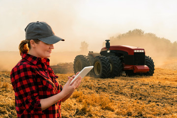 Autocollant - Woman  farmer with digital tablet controls an autonomous tractor on a smart farm