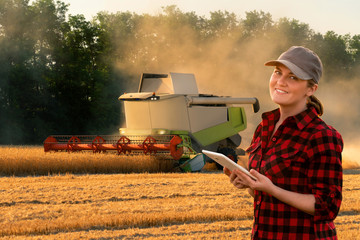Aufkleber - Woman farmer uses a digital tablet control autonomous harvester. Smart farming concept