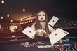 © RomanR - Young woman throwing playing cards in casino