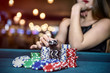 © RomanR - Beautiful woman in casino taking chips from pile