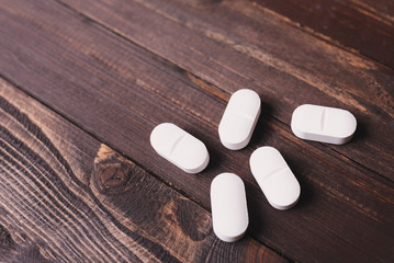 Wall Mural - Large white pills on wooden background