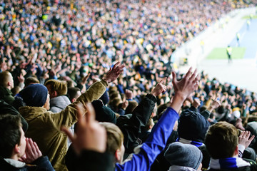 Football fans clapping on the podium of the stadium