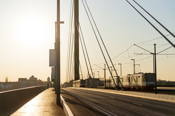 Silhouette view against sunlight of  public transportation trams or train are are moving from opposite direction from pedestrian pathway on bridge without vehicle and traffic.