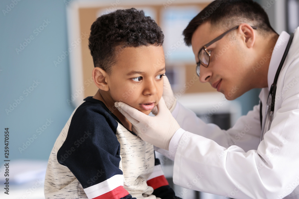 Pediatrician examining African-American boy in clinic