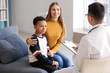 © Pixel-Shot - African-American boy with mother at pediatrician's office
