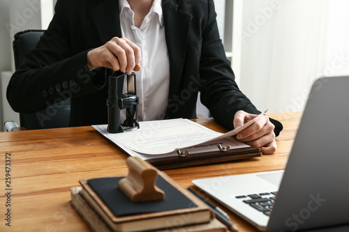 Fotografía Notary public stamping document in office