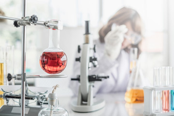 Wall Mural - a young asian woman scientist working in laboratory with test tube microscope and solutions.