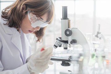 Wall Mural - a young asian woman scientist working in laboratory with test tube microscope and solutions.