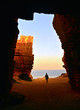 Lonely Young woman exit from Stone cave in Bue Marino beach in Favignana island on sunset in Sicily, Italy