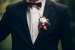 groom or groomsmen closeup, bow tie and boutonniere on suit, confident stylish man