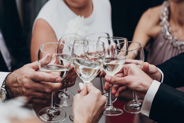 Sticker - people toasting with champagne and wine glasses in hands clinking at luxury wedding reception at restaurant. cheering at stylish celebration. luxury life concept. space for text.