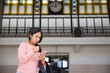 © Mangostar - Worried woman using smartphone in station hall