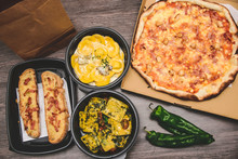 Take Away Italian Pasta Food. Pizza With Box Green Peppers, Garlic Bread, Fetuccine And Ravioli On Plastic Box.
