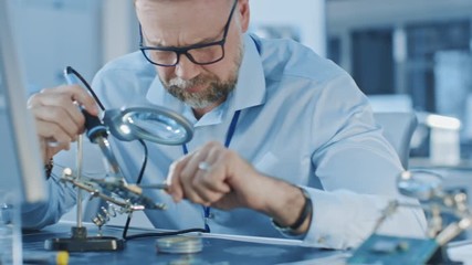 Aufkleber - Moving Shot of Electronics Design Engineers Working with Circuit Boards, Doing Maintenance, Checking Quality and Soldering Motherboard Components. Specialists Working in Bright Office