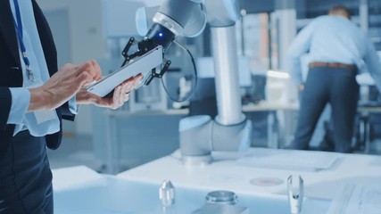Aufkleber - Stylish Female Industrial Robotics Engineer Uses Tablet Computer to Program and Manipulate Robot Arm for Lifting, Moving Objects. Technology Research Facility for Machine Learning and Cloud Computing