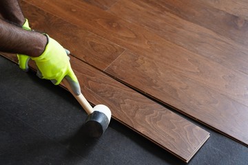 Worker installing hardwood fllors / Home improvement concept, selective focus