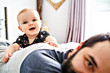 © Louis-Paul Photo - A Baby girl on the back of his father in white bedding at home look nice