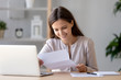 © fizkes - Happy satisfied woman sitting at desk reading positive letter