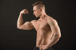 © Alexandr - handsome muscular man on black background showing biceps