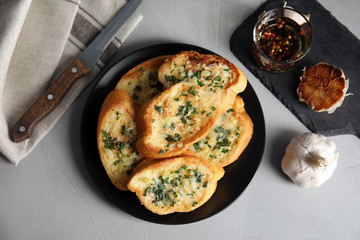 Flat lay composition with tasty garlic bread on table