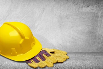 Safety helmet with earphones and goggles on construction background