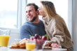 © forma82 - Happy young couple spending nice time together, hugging and kisses each other. Eating breakfast at home