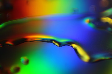 Fototapete - abstract liquid colorful background with water droplets and splash on holographic surface