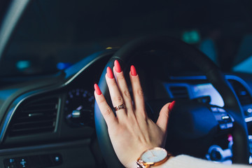 Wall Mural - Woman's hands on the steering wheel driving modern luxury car. Concept woman driving. Hands holding steering wheel while driving. Car inside. Car detailing.