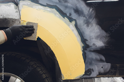 Cuadros en Lienzo Preparation for painting a car element using emery sender by a service technician leveling out before applying a primer after damage to a part of the body in an accident in the vehicle workshop