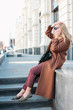 © Galina Zhigalova - Stylish fashionable blonde woman wearing coat and sunglasses speaking on mobile phone, street style photo