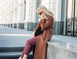 © Galina Zhigalova - Stylish fashionable blonde woman wearing coat and sunglasses speaking on mobile phone, street style photo