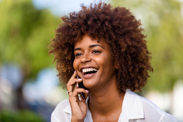 Wall Mural - Outdoor portrait of a Young black African American young woman speaking on mobile phone