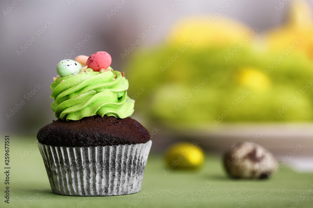 Tasty Easter cupcake on table