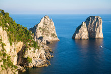 Bright Scenic View Of The Iconic Faraglioni Rocks From The Nearby Cliffside Trail On The Mediterranean Island Of Capri, Italy