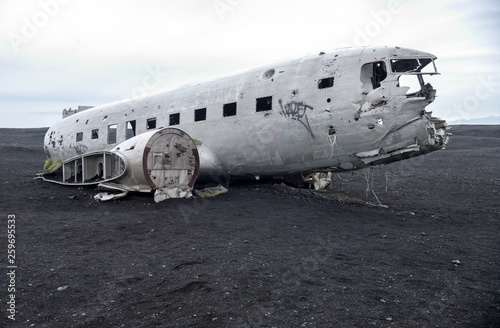 Fotomural Wreckage of crashed airplane Dakota United States Navy Douglas Super DC-3 on the coast of iceland black sand beach