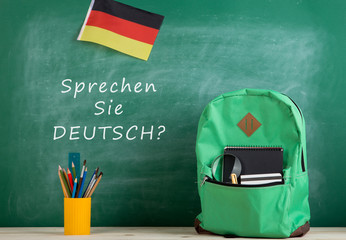Fototapete - green backpack, blackboard with text 